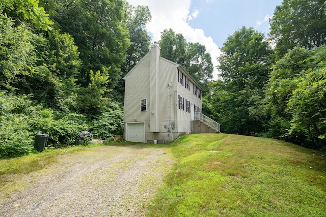 82 Pleasant St, Thomaston, CT 06787 - view of front of house featuring driveway, a garage, a chimney, a front yard, and stairway