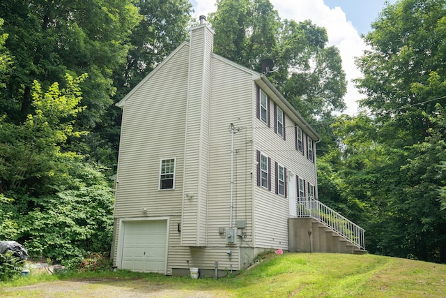 82 Pleasant St, Thomaston, CT 06787 - view of side of property featuring a chimney, a yard, stairs, and a garage