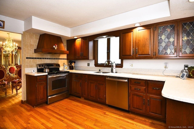 400 Williams Rd, Wallingford, CT 06492 - kitchen with appliances with stainless steel finishes, custom exhaust hood, light countertops, a chandelier, and a textured ceiling
