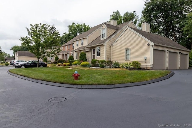 40 Orchard Brook Dr Unit 40, Wethersfield, CT 06109 - view of front of property featuring a chimney, a front yard, driveway, and an attached garage