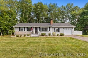 24 Wapping Wood Rd, Ellington, CT 06029 - view of front facade with an attached garage, a chimney, driveway, a front yard, and view of wooded area