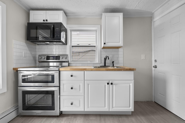 237 Helen St, Bridgeport, CT 06608 - kitchen with black microwave, range with two ovens, wooden counters, a baseboard heating unit, and decorative backsplash