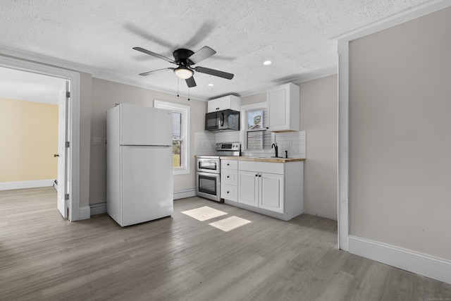 237 Helen St, Bridgeport, CT 06608 - kitchen with freestanding refrigerator, black microwave, range with two ovens, a textured ceiling, and white cabinets