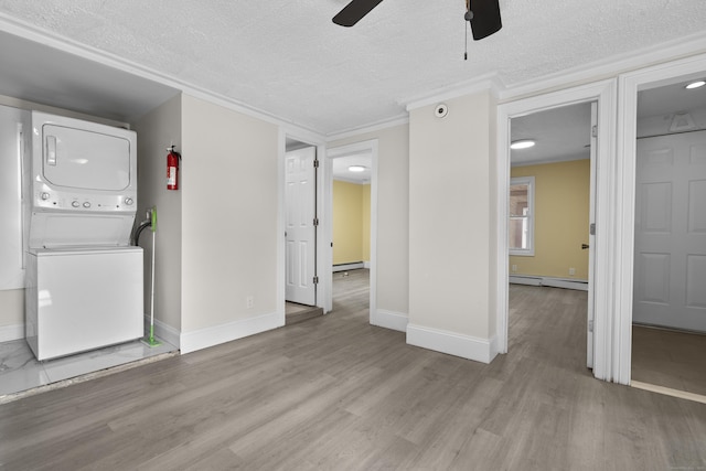 237 Helen St, Bridgeport, CT 06608 - unfurnished living room featuring stacked washing machine and dryer, a baseboard radiator, a ceiling fan, wood finished floors, and a textured ceiling