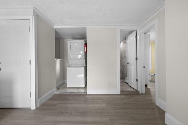 237 Helen St, Bridgeport, CT 06608 - unfurnished bedroom with stacked washer / dryer, a textured ceiling, wood finished floors, and crown molding