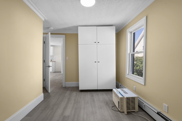 237 Helen St, Bridgeport, CT 06608 - unfurnished bedroom featuring a textured ceiling, light wood-style flooring, ornamental molding, a baseboard heating unit, and a closet