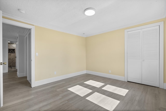 237 Helen St, Bridgeport, CT 06608 - unfurnished bedroom with wood finished floors, a textured ceiling, a closet, and ornamental molding
