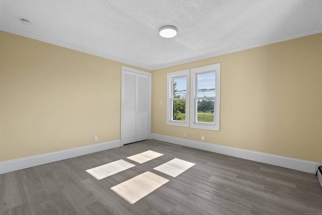 237 Helen St, Bridgeport, CT 06608 - unfurnished bedroom featuring a textured ceiling, wood finished floors, a closet, and ornamental molding