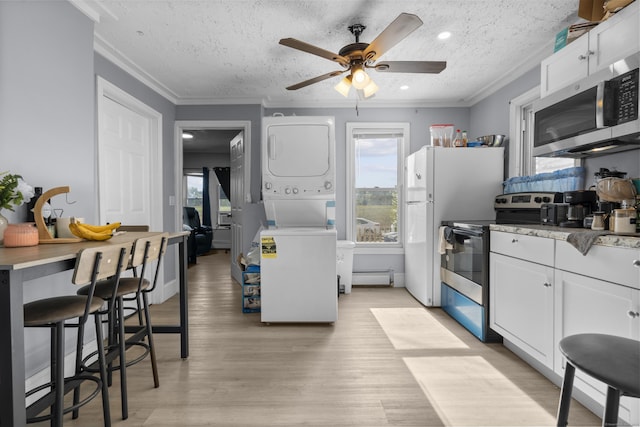 237 Helen St, Bridgeport, CT 06608 - kitchen with stainless steel appliances, estacked washer and dryer, healthy amount of natural light, ceiling fan, and crown molding