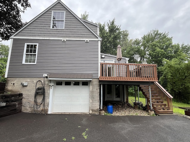 57 S Main St, East Granby, CT 06026 - back of house with stairway, a wooden deck, an attached garage, and driveway