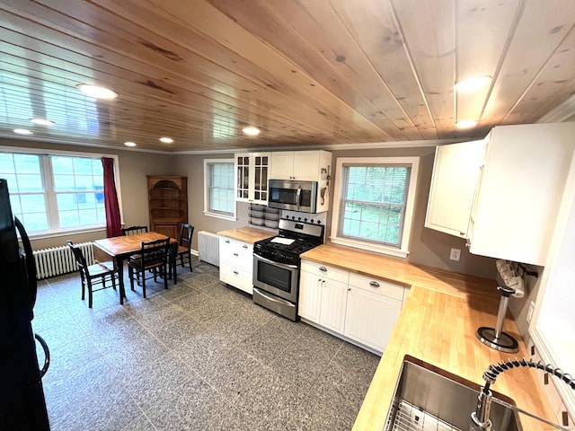 57 S Main St, East Granby, CT 06026 - kitchen with wood counters, stainless steel appliances, radiator, wooden ceiling, and plenty of natural light