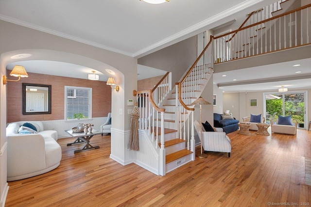 6 Tonetta Cir, Norwalk, CT 06855 - entrance foyer featuring wood finished floors, stairs, ornamental molding, a wainscoted wall, and arched walkways