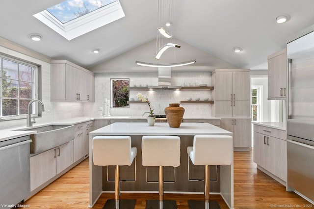 6 Tonetta Cir, Norwalk, CT 06855 - kitchen with appliances with stainless steel finishes, open shelves, lofted ceiling, wall chimney range hood, and a kitchen breakfast bar