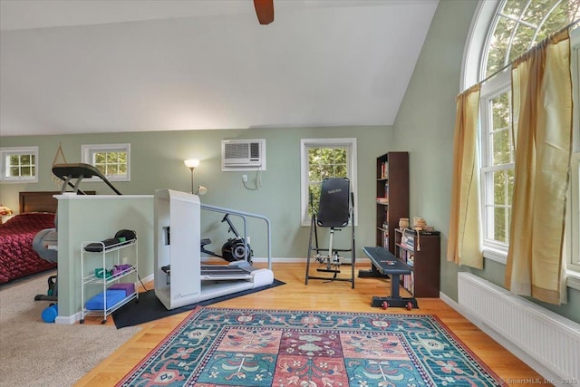 30 Lake Rd, Columbia, CT 06237 - workout area featuring radiator heating unit, vaulted ceiling, a wall mounted air conditioner, a ceiling fan, and wood finished floors