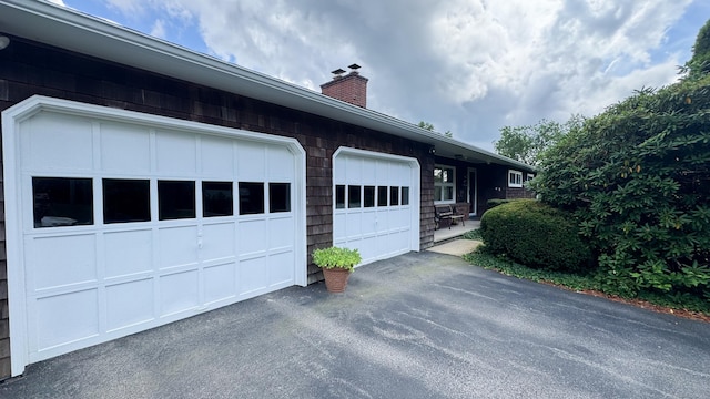 70 River Rd, Preston, CT 06365 - view of property exterior featuring a chimney, asphalt driveway, and an attached garage