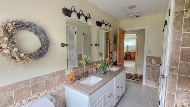 70 River Rd, Preston, CT 06365 - full bath featuring tile walls, double vanity, tile patterned floors, and a wainscoted wall