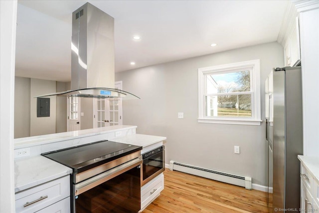18 Greenbrier Rd, East Hartford, CT 06118 - kitchen with a baseboard radiator, stainless steel appliances, island exhaust hood, white cabinetry, and light wood-style flooring