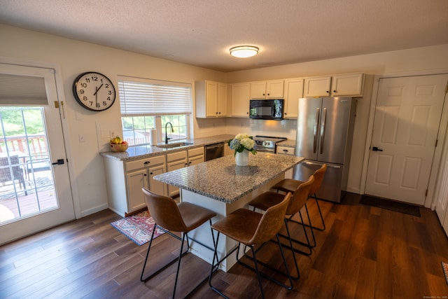 14 Greenview Ter, Middletown, CT 06457 - kitchen featuring stainless steel appliances, dark wood finished floors, white cabinetry, a breakfast bar area, and a kitchen island