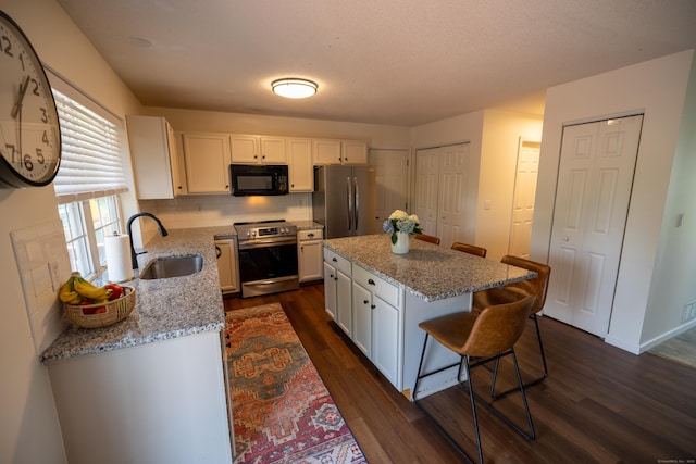 14 Greenview Ter, Middletown, CT 06457 - kitchen featuring appliances with stainless steel finishes, dark wood finished floors, white cabinets, and a breakfast bar area