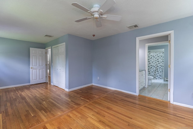 21 Brentwood Rd, New Milford, CT 06776 - unfurnished bedroom with wood finished floors, a closet, a textured ceiling, baseboard heating, and ceiling fan