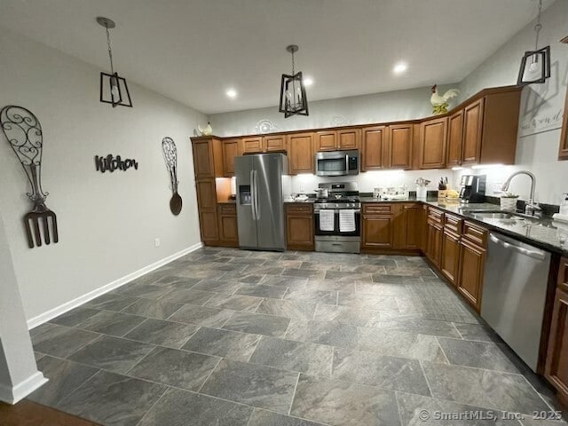 36 Todd St Unit 507, Hamden, CT 06518 - kitchen featuring appliances with stainless steel finishes, dark stone finish floors, brown cabinets, pendant lighting, and recessed lighting
