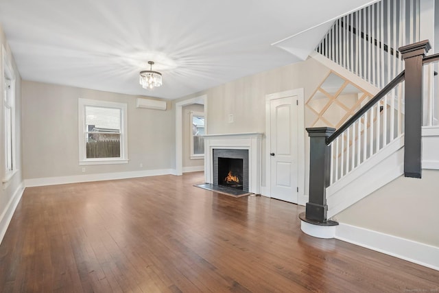 79 W Wooster St, Danbury, CT 06810 - unfurnished living room with a wall mounted air conditioner, a chandelier, hardwood / wood-style floors, stairway, and a fireplace with flush hearth