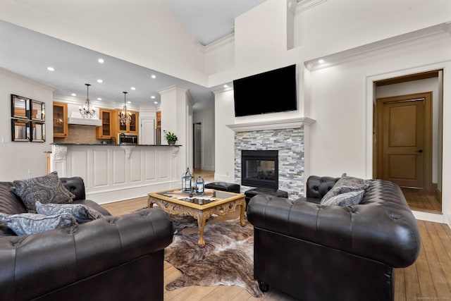 274 Sharon Tpke, Goshen, CT 06756 - living room with light wood-type flooring, crown molding, a stone fireplace, a chandelier, and recessed lighting