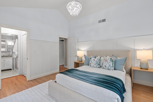 28 Codfish Ln, Weston, CT 06883 - bedroom featuring a decorative wall, light wood-style flooring, a chandelier, a wainscoted wall, and ensuite bath