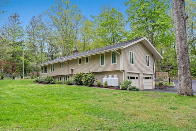 28 Codfish Ln, Weston, CT 06883 - raised ranch featuring an attached garage, driveway, a chimney, and a front yard