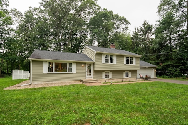 181 Ridge Rd, Madison, CT 06443 - tri-level home featuring driveway, a chimney, a garage, and view of wooded area
