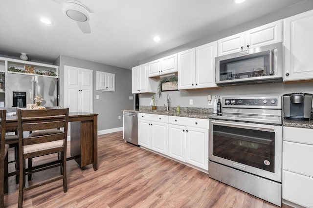 845 Five Mile River Rd, Putnam, CT 06260 - kitchen featuring stainless steel appliances, light wood-type flooring, stone counters, white cabinets, and recessed lighting