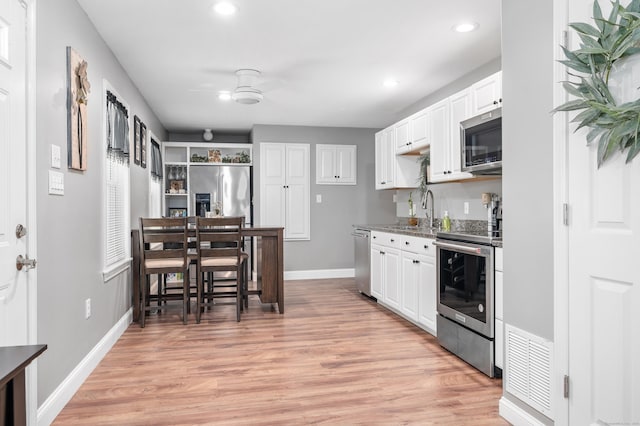 845 Five Mile River Rd, Putnam, CT 06260 - kitchen featuring appliances with stainless steel finishes, a ceiling fan, light wood-style floors, white cabinets, and recessed lighting