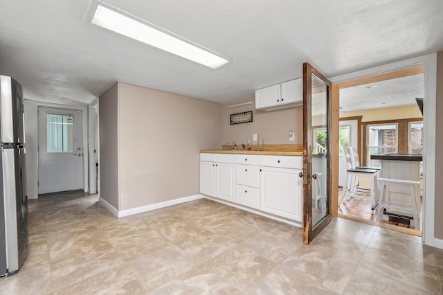 845 Five Mile River Rd, Putnam, CT 06260 - kitchen with freestanding refrigerator, white cabinets, and light countertops