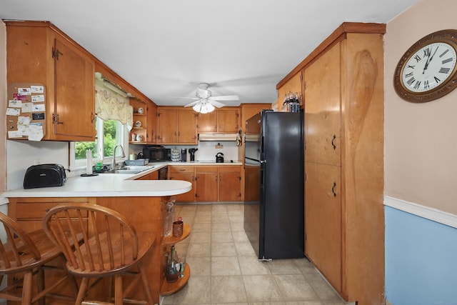 97 Edgewood Ave, Thomaston, CT 06787 - kitchen featuring freestanding refrigerator, a peninsula, brown cabinetry, light countertops, and ceiling fan
