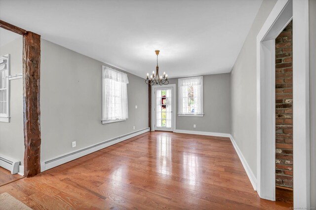 122 Nooks Hill Rd, Cromwell, CT 06416 - empty room featuring a baseboard heating unit, hardwood / wood-style flooring, and a chandelier
