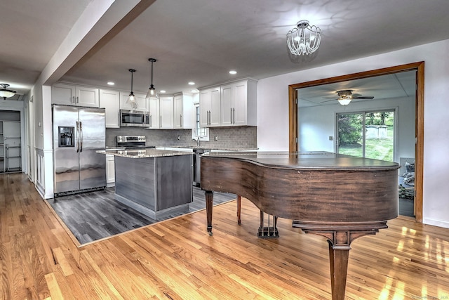 43 Berner Ter, Milford, CT 06460 - kitchen with appliances with stainless steel finishes, dark wood-style floors, a ceiling fan, white cabinets, and a center island