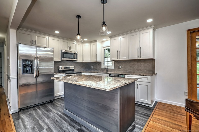 43 Berner Ter, Milford, CT 06460 - kitchen with stainless steel appliances, dark wood finished floors, backsplash, light stone countertops, and white cabinetry