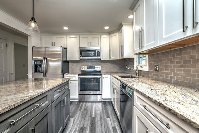 43 Berner Ter, Milford, CT 06460 - kitchen with appliances with stainless steel finishes, white cabinets, dark wood finished floors, light stone countertops, and decorative backsplash