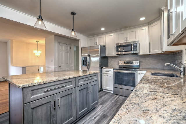43 Berner Ter, Milford, CT 06460 - kitchen featuring stainless steel appliances, dark wood-style floors, decorative backsplash, white cabinetry, and pendant lighting