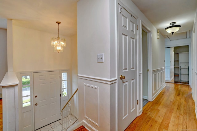 43 Berner Ter, Milford, CT 06460 - foyer entrance featuring a chandelier, wainscoting, a decorative wall, and light wood-style floors