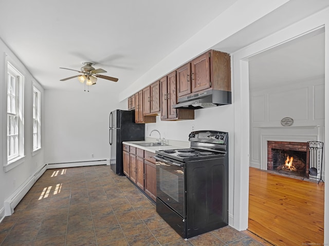 161 White St, Stratford, CT 06615 - kitchen with black electric range, under cabinet range hood, a ceiling fan, a fireplace, and freestanding refrigerator