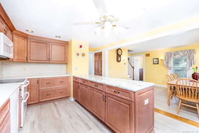 15 Boardman St, Bristol, CT 06010 - kitchen featuring white appliances, light wood finished floors, a peninsula, a ceiling fan, and light stone countertops