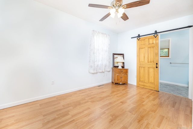 15 Boardman St, Bristol, CT 06010 - empty room featuring a barn door, light wood finished floors, and ceiling fan
