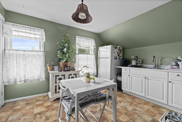 103 Eaton St, Bridgeport, CT 06604 - kitchen featuring freestanding refrigerator, white cabinets, stone finish flooring, and vaulted ceiling