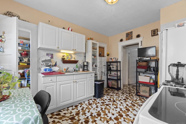 103 Eaton St, Bridgeport, CT 06604 - kitchen with tile patterned floors, white cabinets, and light countertops