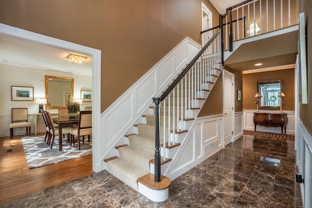 6 Salisbury Way, Farmington, CT 06032 - stairway featuring a high ceiling, a decorative wall, a wainscoted wall, and crown molding