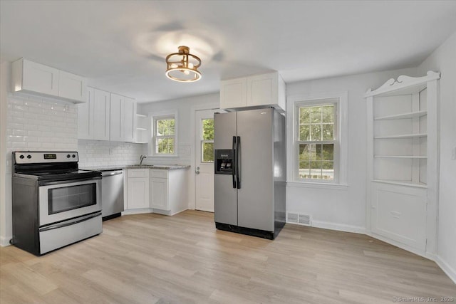 270 Hills St, East Hartford, CT 06118 - kitchen featuring appliances with stainless steel finishes, open shelves, healthy amount of natural light, and white cabinetry