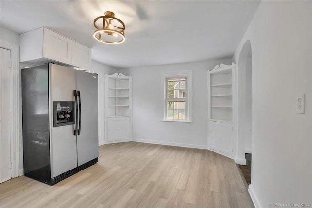 270 Hills St, East Hartford, CT 06118 - kitchen featuring stainless steel refrigerator with ice dispenser, light wood-type flooring, white cabinets, and arched walkways