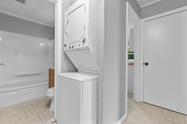 17 Norwood Rd, New Haven, CT 06513 - laundry area with estacked washer and dryer, ornamental molding, light tile patterned flooring, and a textured ceiling