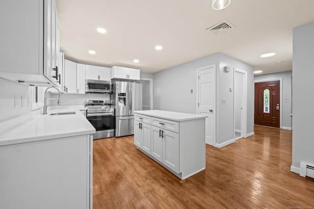 7 Woodmont Rd, Avon, CT 06001 - kitchen featuring stainless steel appliances, white cabinetry, light wood-style floors, light countertops, and a center island